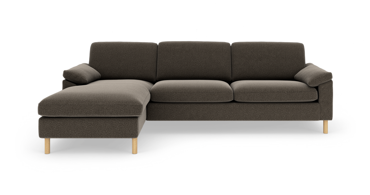 Mørkegrå modulsofa med venstrevendt chaiselong og lyse træben, frilagt på hvid baggrund.