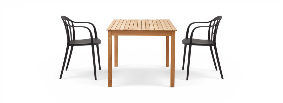 Ribbet træbord i natur med to sorte stole, set forfra.
