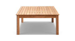 Rektangulært bord i lyst teak med lamel-bordplade, frontal vinkel på hvid baggrund.