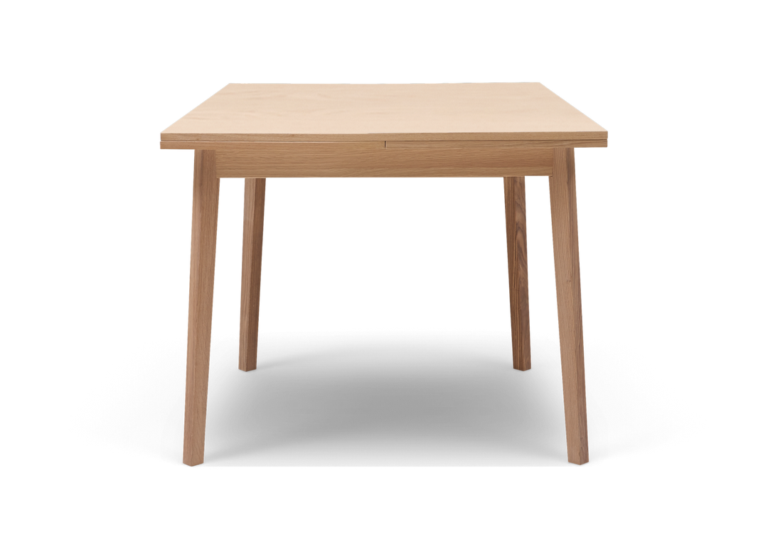 Frontvisning af et minimalistisk spisebord i lys eg mod hvid baggrund.