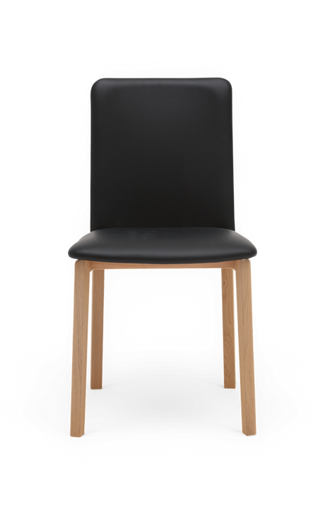 Sort stol med sæde og ryg i læderlook og ben i eg, set forfra – minimalistisk spisebordsstol.