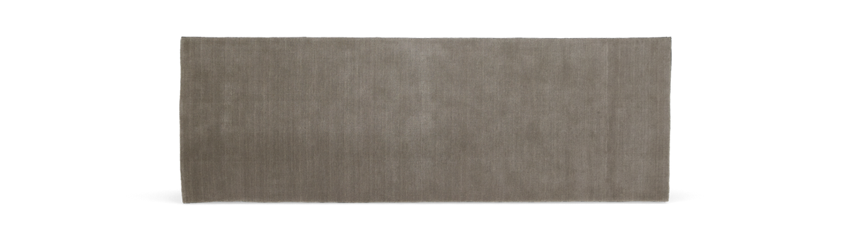 Moderne, minimalistisk stue med sofa og puder i neutrale nuancer.