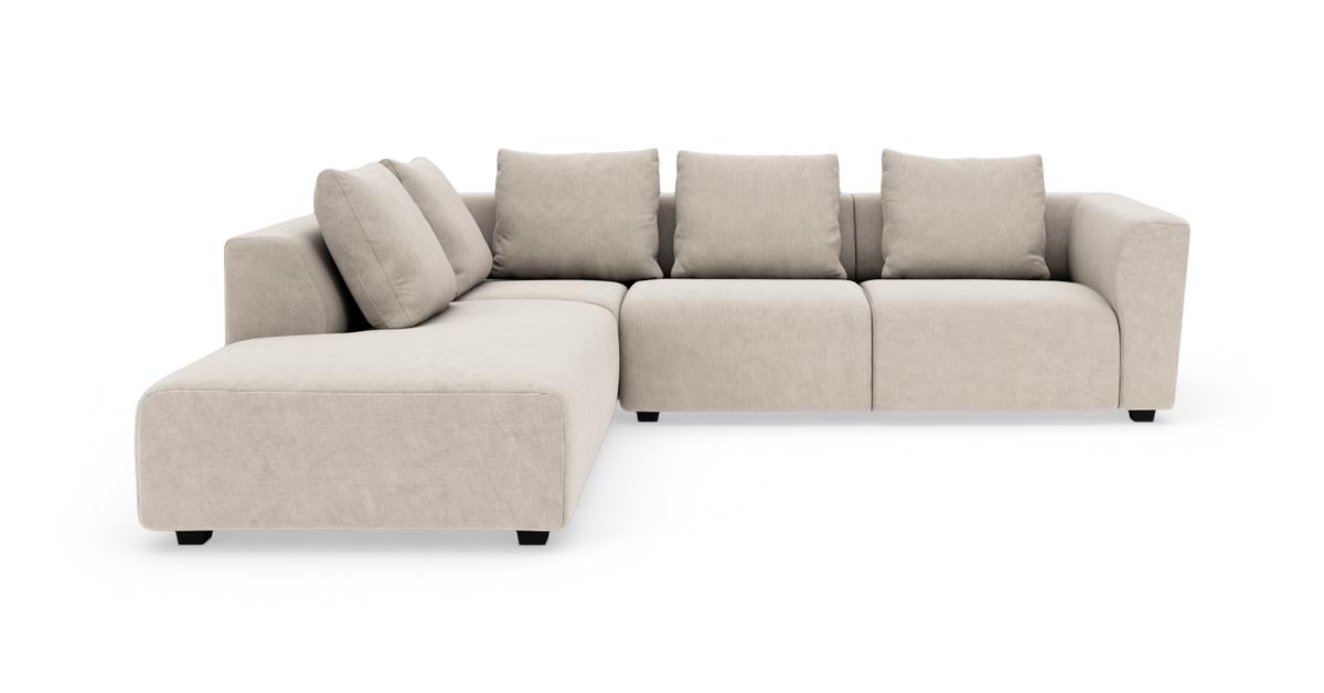 Beige modulsofa med chaiselong og fire ryghynder, frilagt på hvid baggrund.