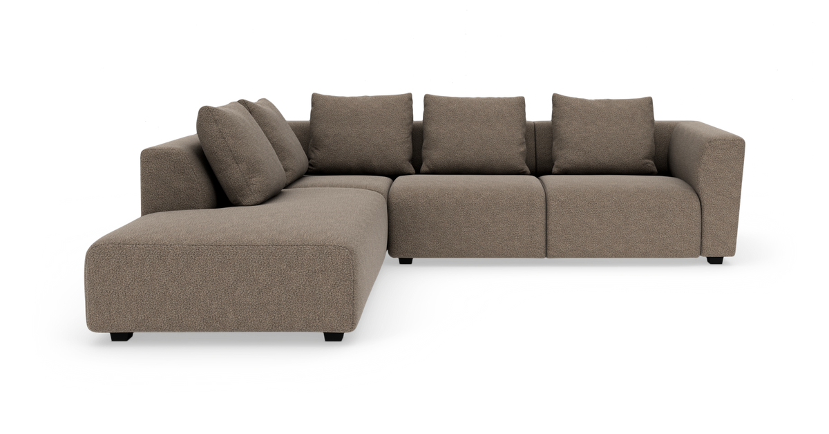 Brun modulsofa i stof med chaiselong til venstre og fire ryghynder, fotograferet mod hvid baggrund.