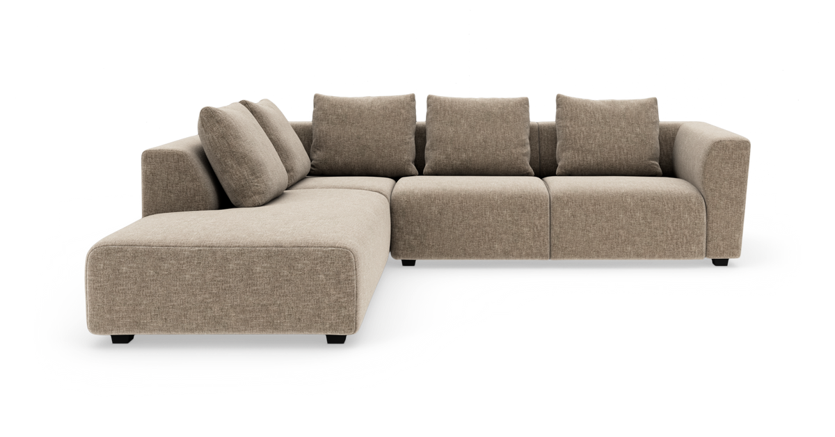 Beige L-formet modulsofa med chaiselong til venstre og fem ryghynder, fritstående mod hvid baggrund.