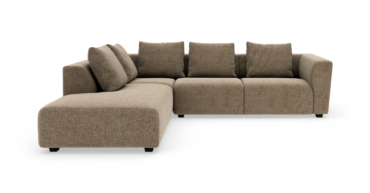 Modulær hjørnesofa i beige stof med chaiselong til venstre, løse ryghynder og blødt afrundede armlæn.