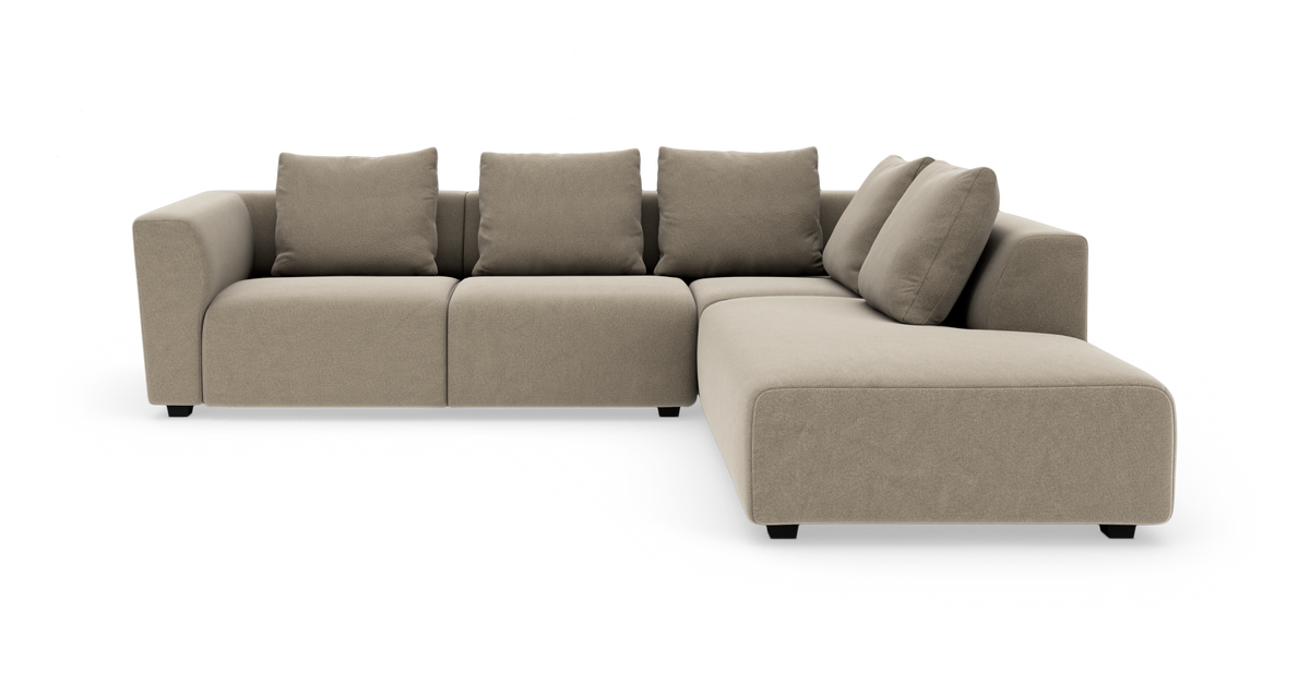 Beige L‑formet modulsofa med fire rygpuder, fritstående på hvid baggrund.