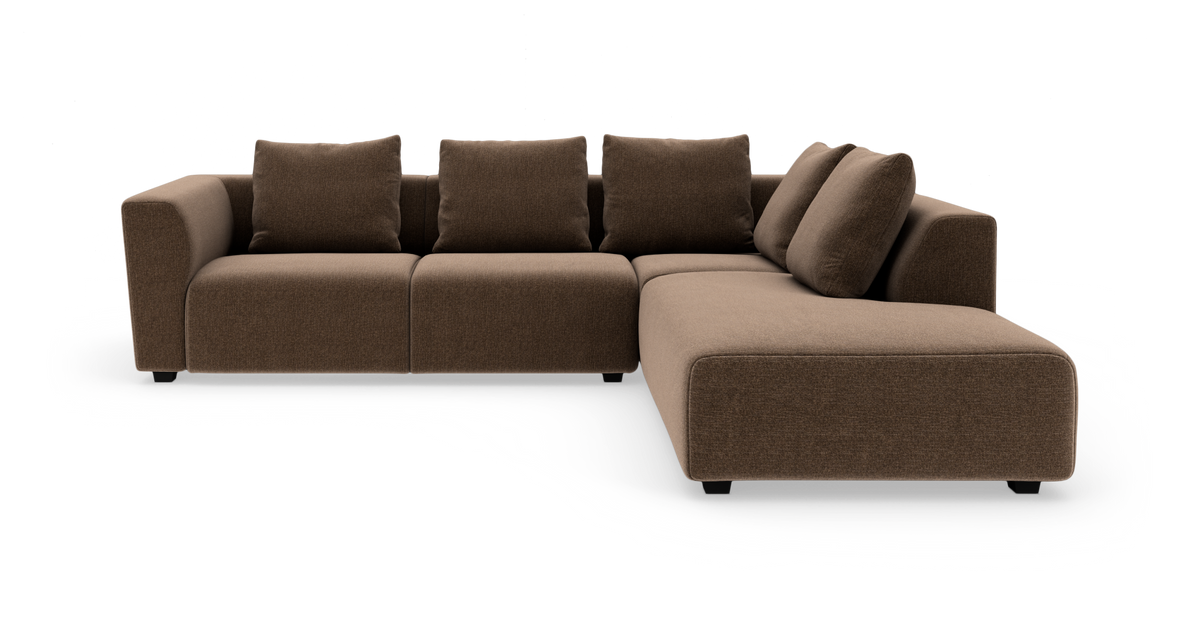 Brun L-formet modulsofa med chaiselong til højre, fire rygpuder og to hjørnepuder, fritstående mod hvid baggrund.