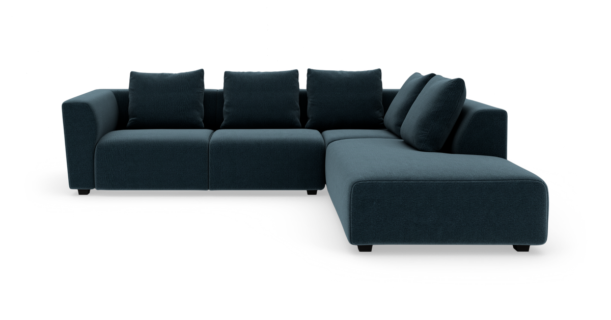 Mørkeblå modulsofa i L‑form med fem løse ryghynder og lavprofilben.