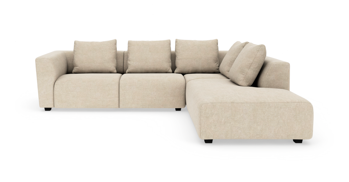 Beige L-formet modulsofa med fire ryghynder og chaiselong til højre på hvid baggrund.