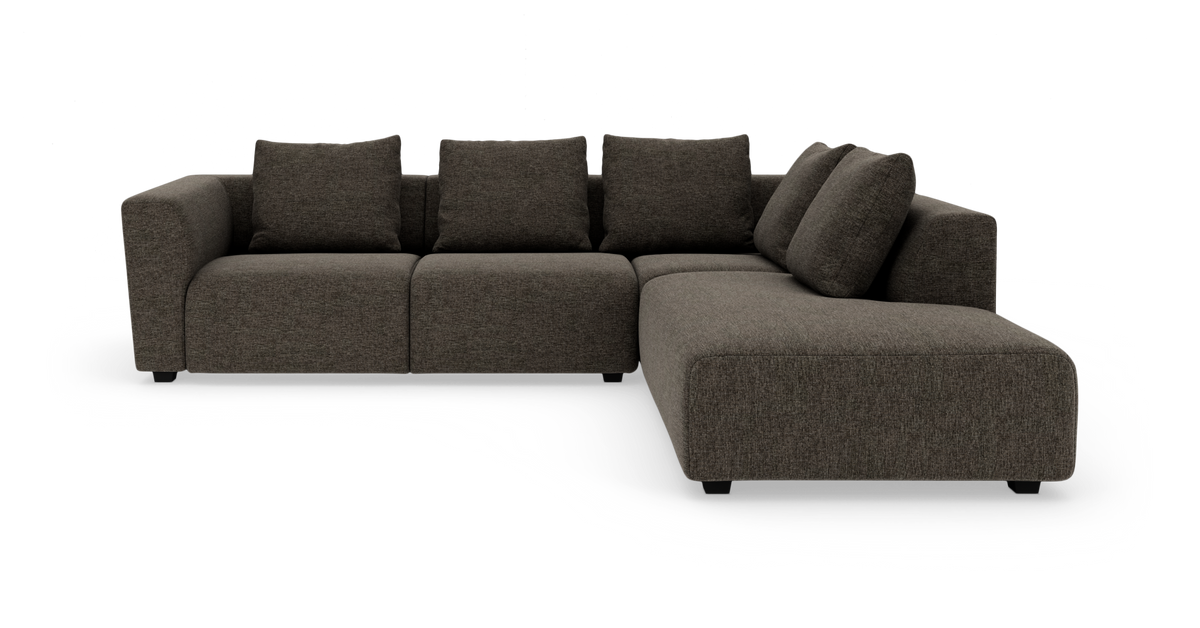 Mørkegrå modulsofa i L‑form med chaiselong til højre, fritlagt på hvid baggrund.