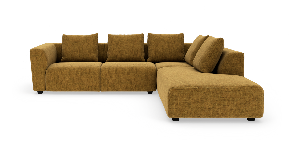Modulær hjørnesofa i sennepsgul tekstil med chaiselong til højre, fire ryghynder og to løse puder.