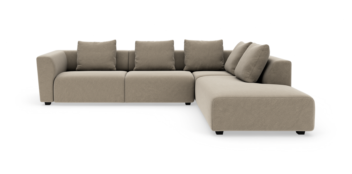 Beige modulsofa i L‑form med fire rygpuder og bred højrevendt chaiselong.