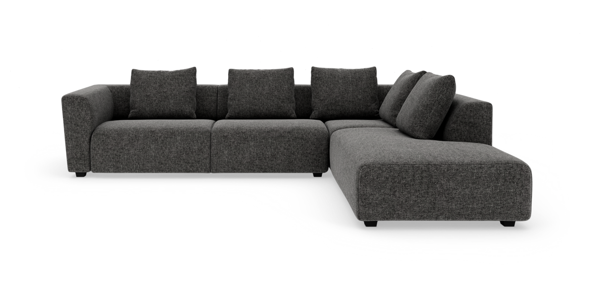 Mørkegrå modul hjørnesofa med chaiselong til højre og store ryghynder, frilagt på hvid baggrund.