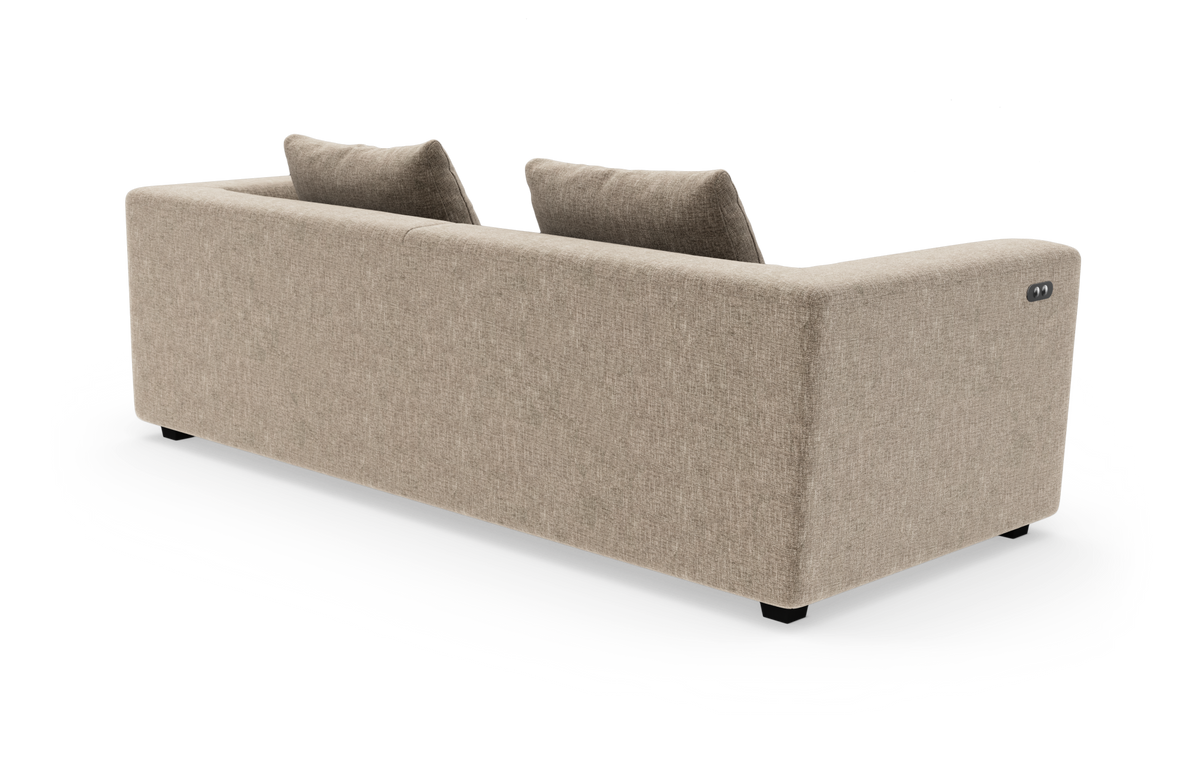 Beige stofsofa set bagfra i studieopsætning, to ryghynder og diskret knappanel på højre armlæn.