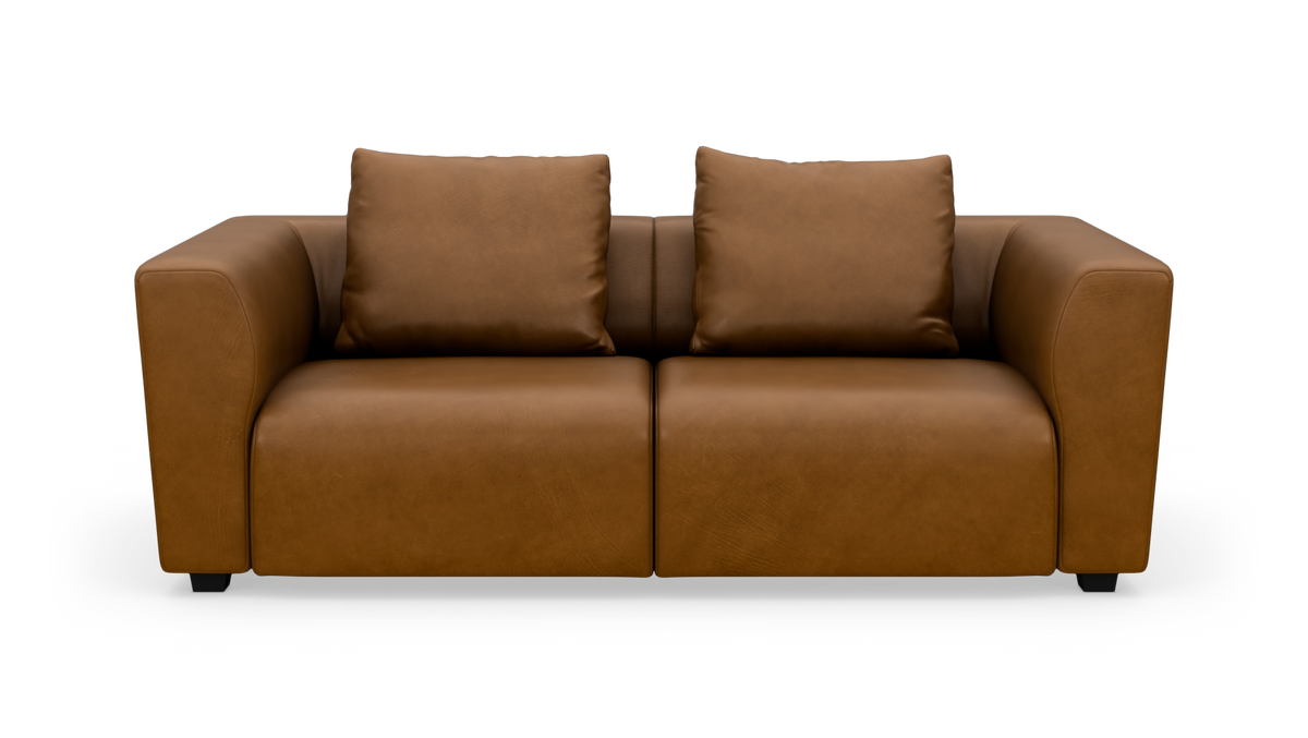 Brun lædersofa med to store ryghynder, fotograferet forfra på hvid baggrund.