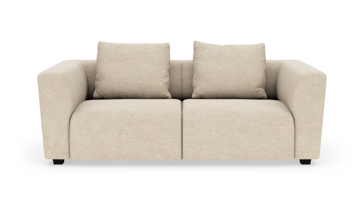Beige tosæders sofa med to matchende puder, isoleret på hvid baggrund.