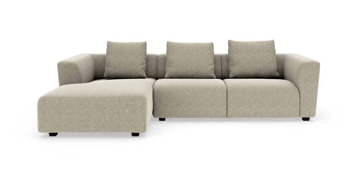 Beige modulsofa med venstrevendt chaiselong og tre puder, frilagt på hvid baggrund.