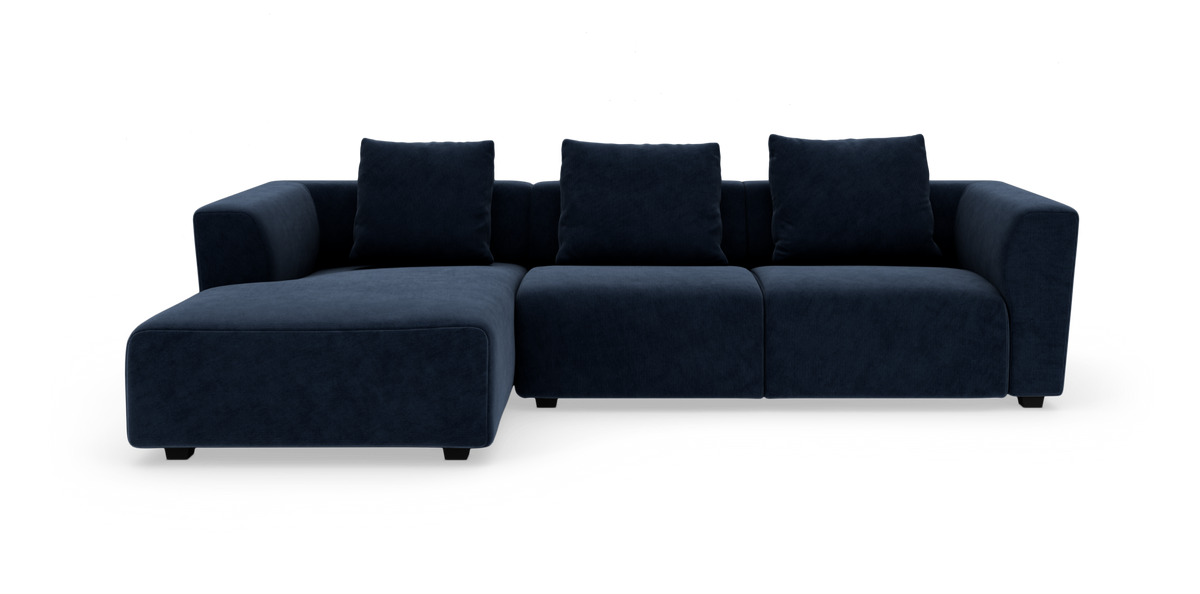 Mørkeblå modulsofa med chaiselong til venstre, set direkte forfra på hvid baggrund.