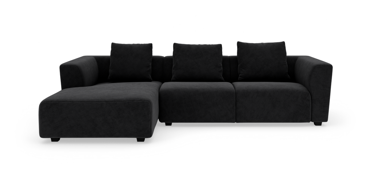 Sort modulsofa med venstre chaiselong, tre ryghynder og brede armlæn.