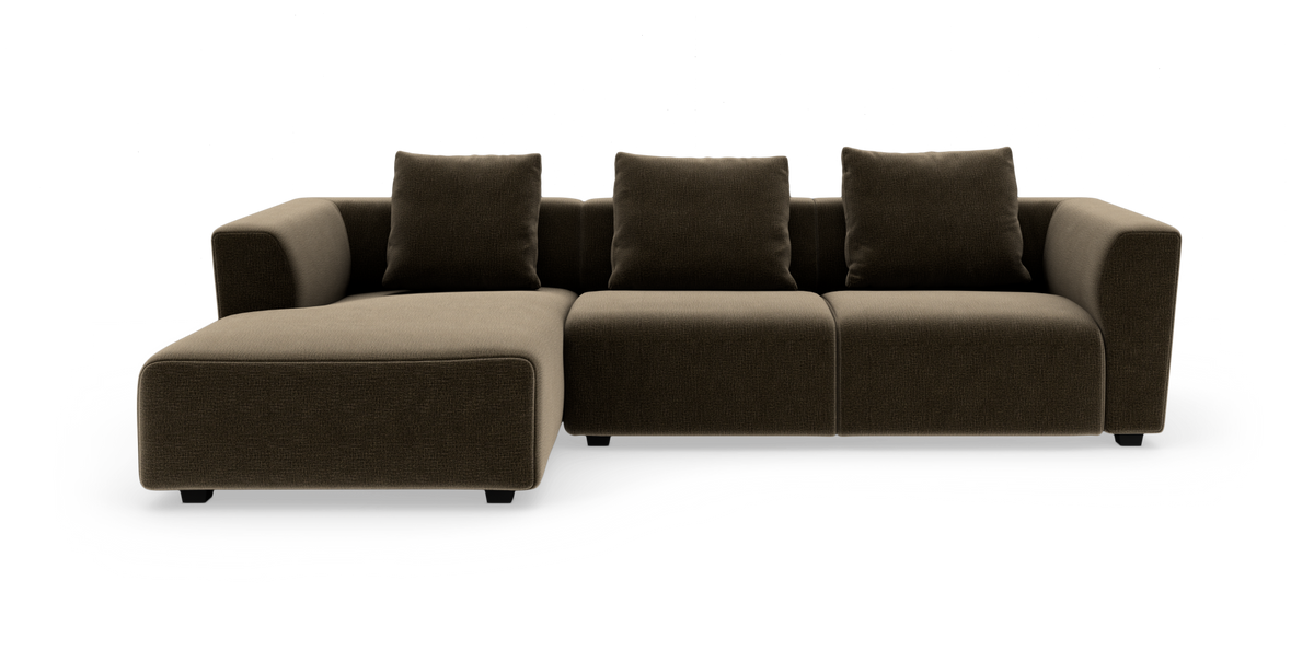 Modulsofa i mørkebrun tekstil med venstrevendt chaiselong, tre sædemoduler og tre rygpuder, frilagt på hvid baggrund.