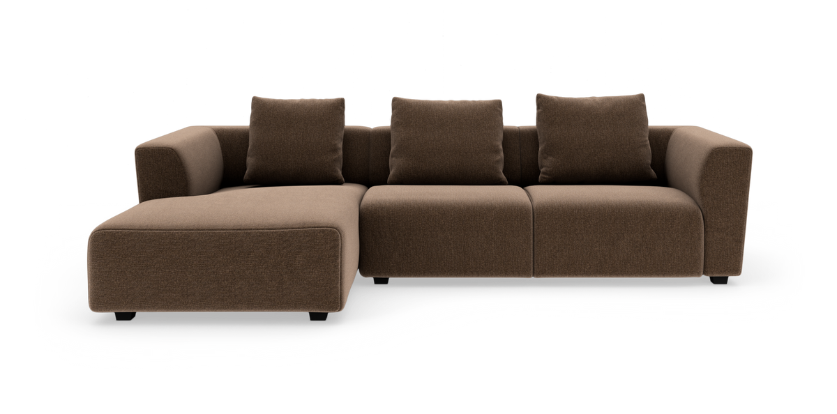 Brun modulsofa med venstrevendt chaiselong, tre sæder og løse ryghynder, frilagt på hvid baggrund.