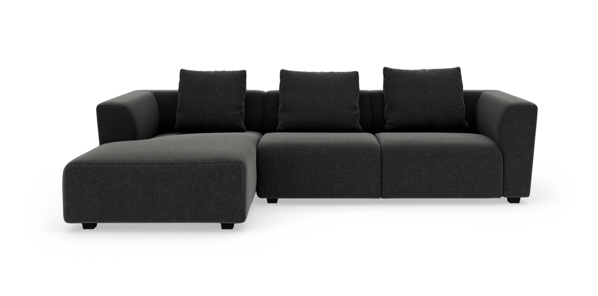 Mørkegrå modulsofa med venstrevendt chaiselong og tre ryghynder, frilagt på hvid baggrund.