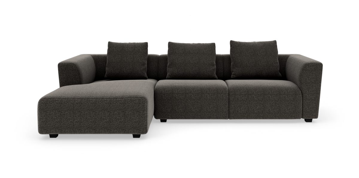 Mørkegrå modulsofa med venstrevendt chaiselong og tre ryghynder, fotograferet forfra mod hvid baggrund.