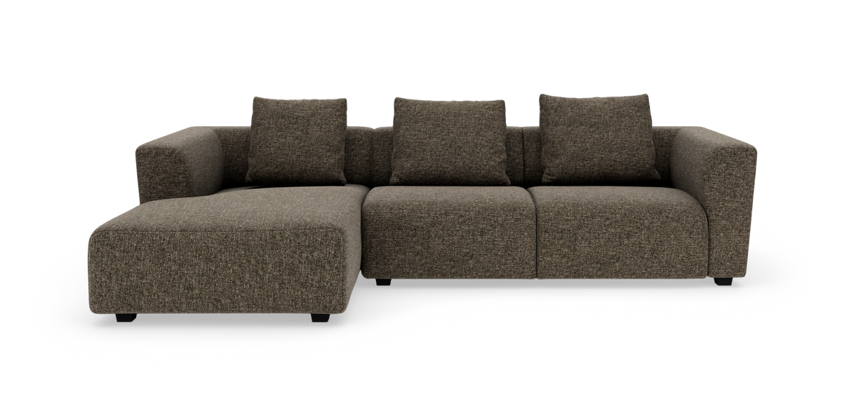 Brun modulsofa med chaiselong og fire puder, set forfra på hvid baggrund.