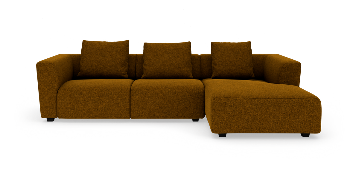 Modulsofa med højrevendt chaiselong i sennepsgul bouclé med fire ryghynder, fritstående mod hvid baggrund.