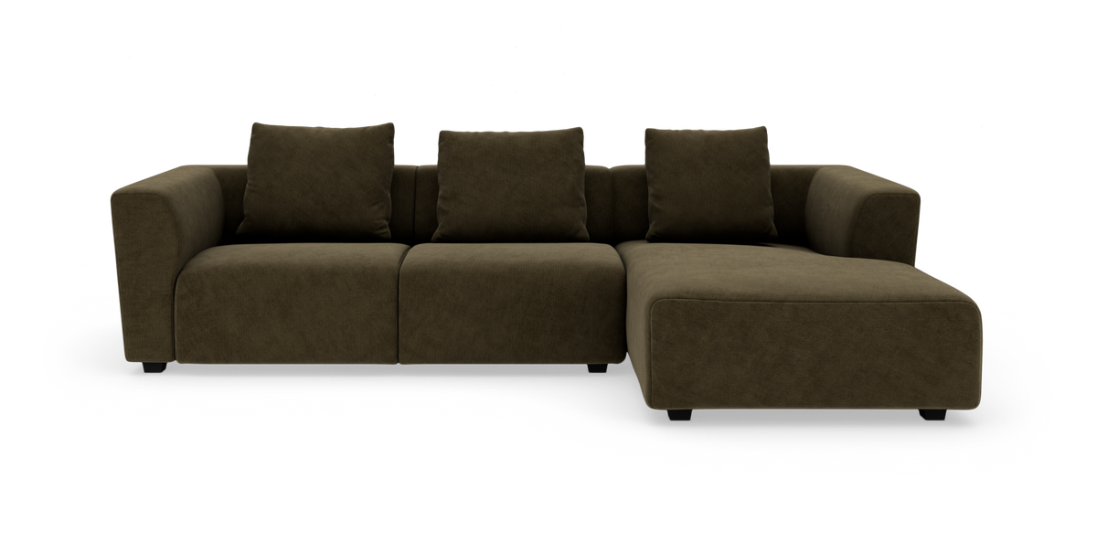 Modulsofa i mørk olivgrøn polstring med chaiselong til højre, tre ryghynder og lave fødder, fotograferet forfra.