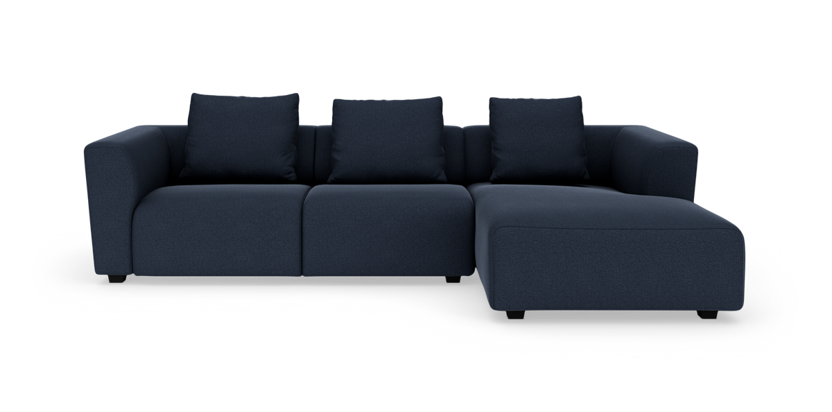 Mørkeblå hjørnesofa med chaiselong til højre, tre sædehynder og tre rygpuder på hvid baggrund.