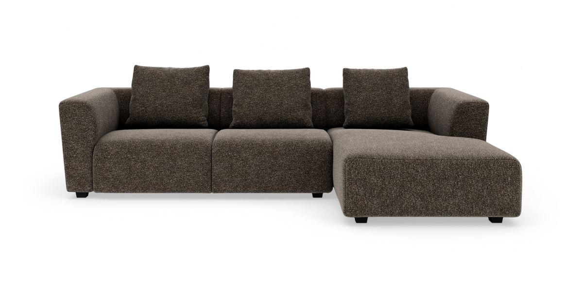 Brun modulsofa med chaiselong til højre og fire puder, frilagt på hvid baggrund.