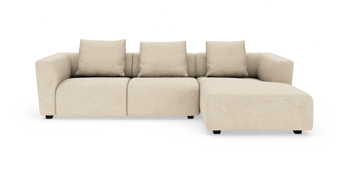 Beige modulsofa med chaiselong til højre, frilagt på hvid baggrund.