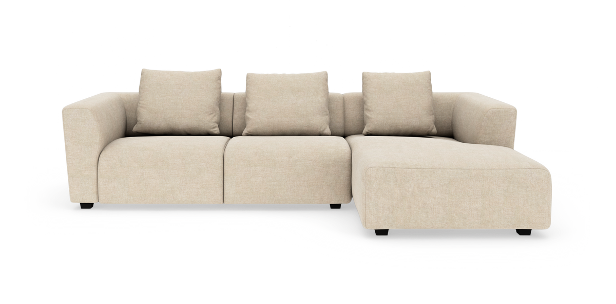 Beige modulsofa med chaiselong til højre, frilagt på hvid baggrund.