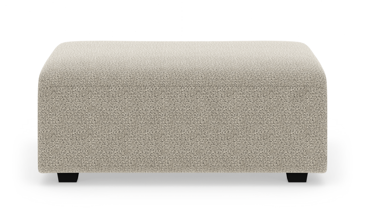 Beige rektangulær puf/ottoman i tekstil med afrundede hjørner, frilagt på hvid baggrund.