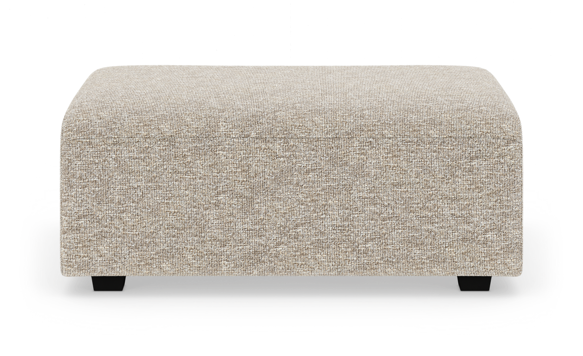 Beige rektangulær puf/ottoman i tekstil med lave sorte ben, frilagt på hvid baggrund.