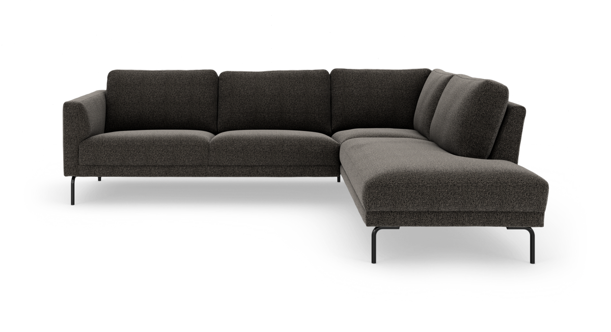Mørkegrå L‑formet hjørnesofa med højre chaiselong på slanke sorte ben, frilagt på hvid baggrund.