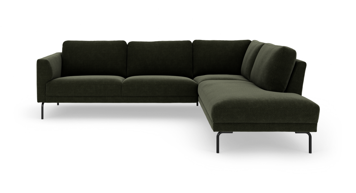Mørkegrøn L-sofa med chaiselong til højre på slanke sorte ben, frilagt mod hvid baggrund.