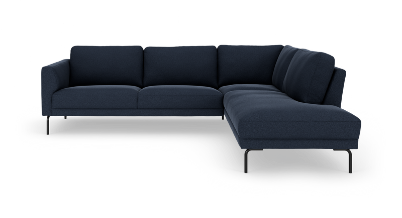 Mørkeblå L‑sofa med chaiselong til højre og slanke sorte ben, frilagt på hvid baggrund._ps