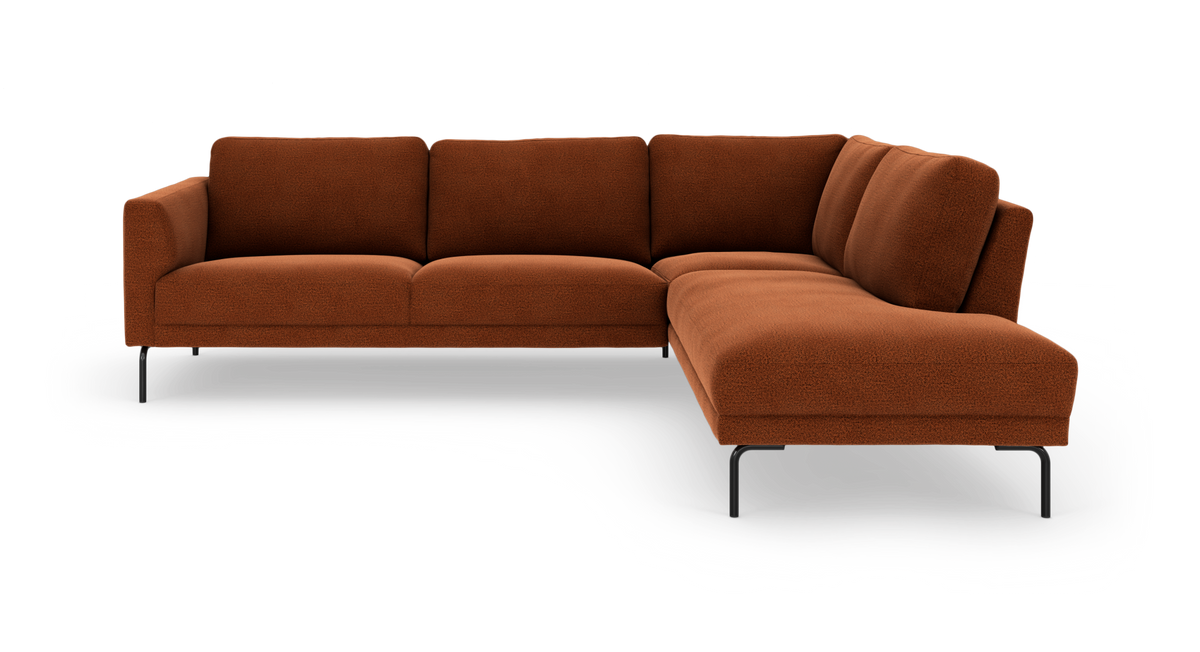 Rustfarvet L-formet modulsofa med chaiselong til højre og slanke sorte ben.