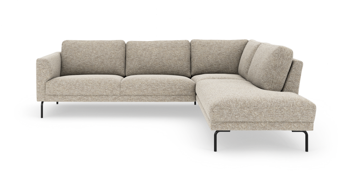 Beige L‑formet modulsofa med chaiselong til højre og slanke sorte metalben, frilagt på hvid baggrund.