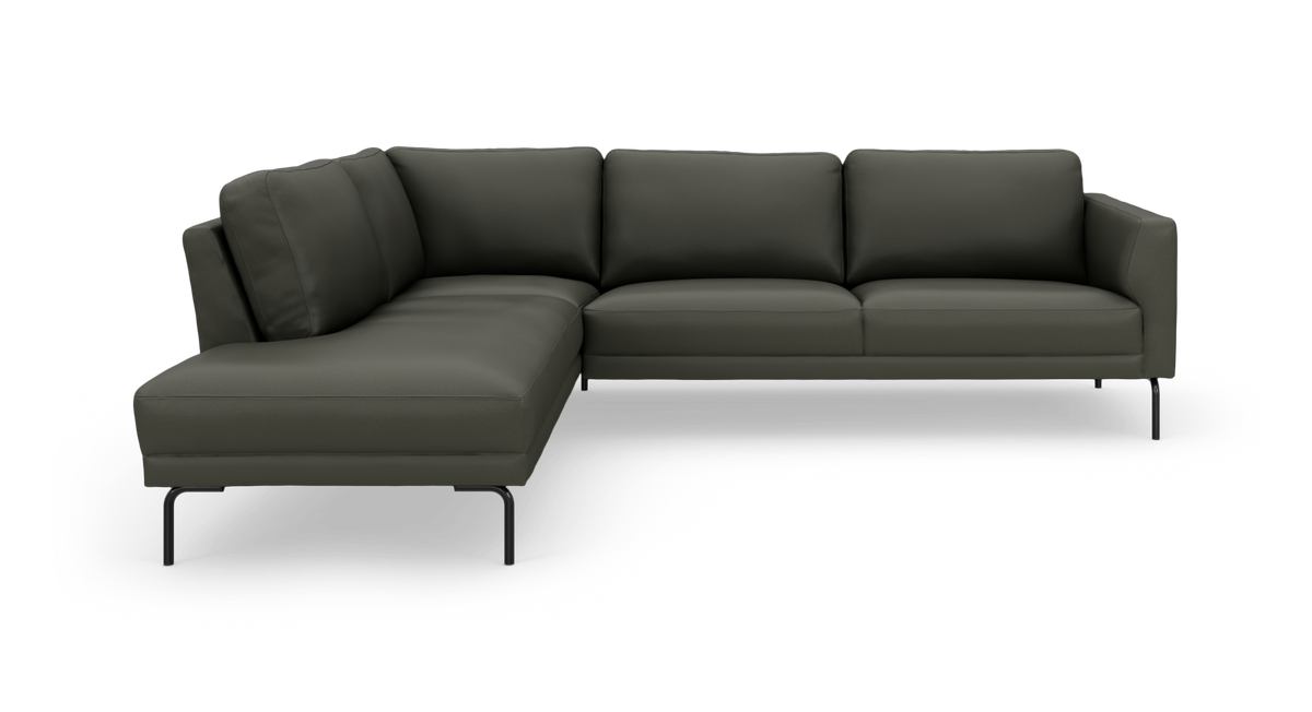 Mørkegrøn L‑sofa med chaiselong til venstre og slanke sorte metalben, frilagt på hvid baggrund.