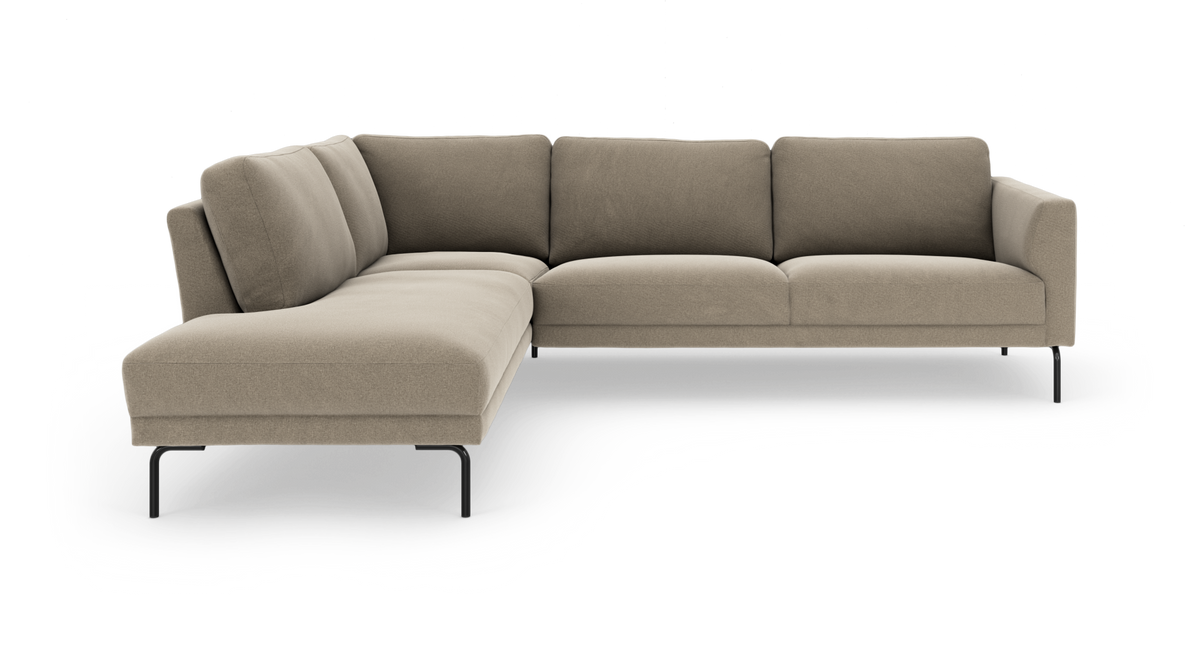 Beige L‑formet modulsofa med chaiselong til venstre og slanke sorte ben, frilagt på hvid baggrund.
