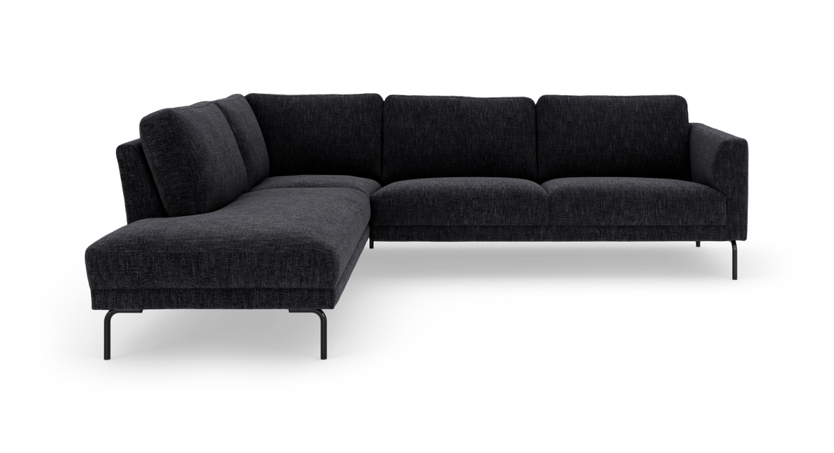 Mørkegrå L-formet modulsofa med chaiselong til venstre og slanke metalben, fritlagt på hvid baggrund.