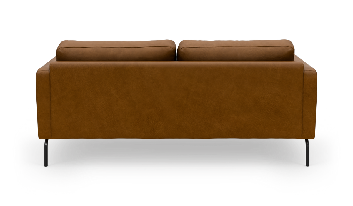 Brun lædersofa set bagfra med slanke sorte ben, frilagt på hvid baggrund.