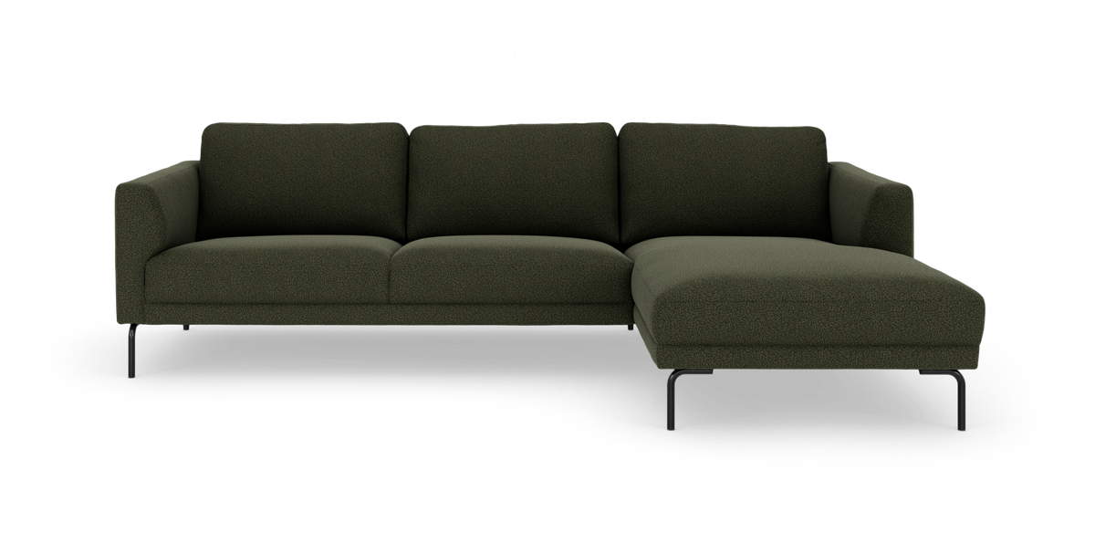 Mørkegrøn hjørnesofa med chaiselong til højre og sorte metalben, frilagt på hvid baggrund.