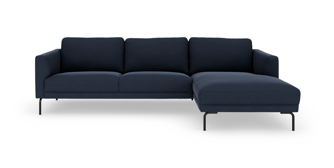 Mørkeblå hjørnesofa med chaiselong til højre, slanke sorte ben.
