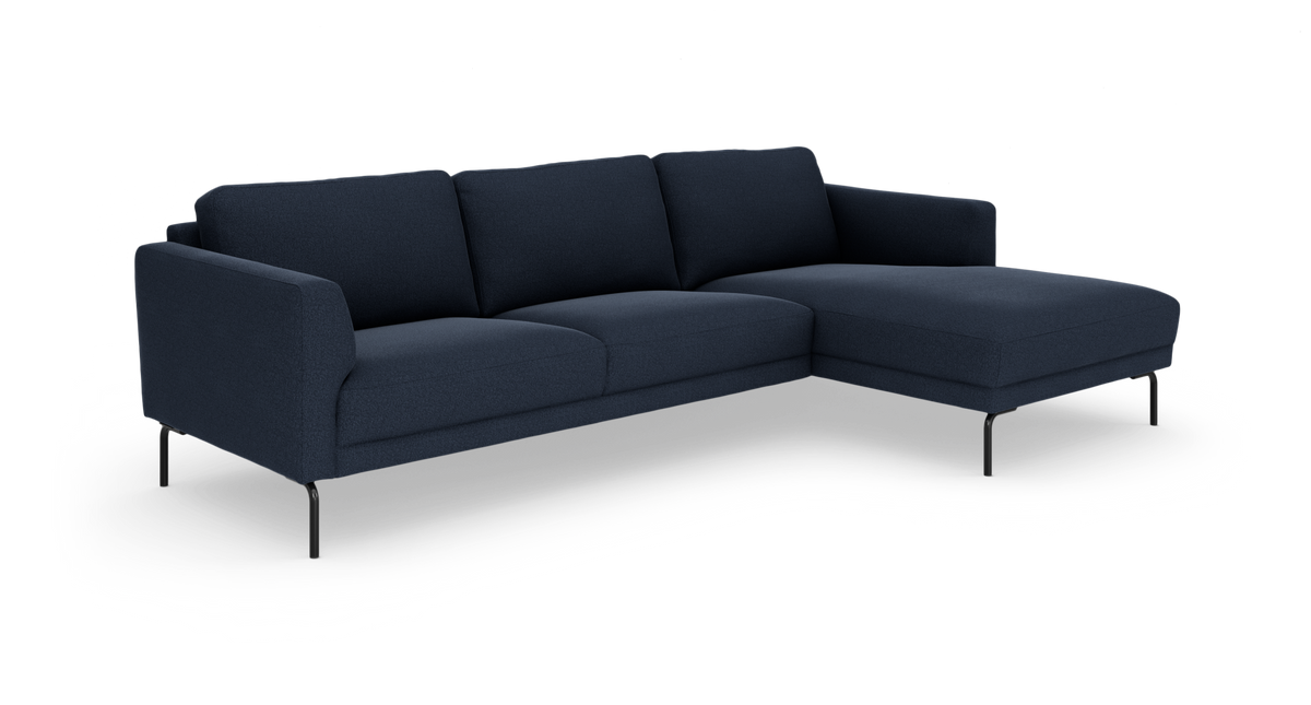 Mørkeblå hjørnesofa med højrevendt chaiselong og slanke sorte ben, frilagt på hvid baggrund.
