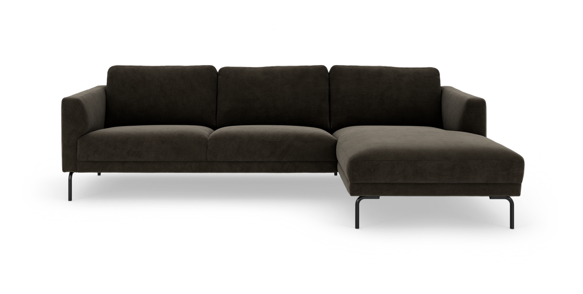 Mørkebrun modulsofa med chaiselong til højre og slanke sorte metalben, frilagt mod hvid baggrund.